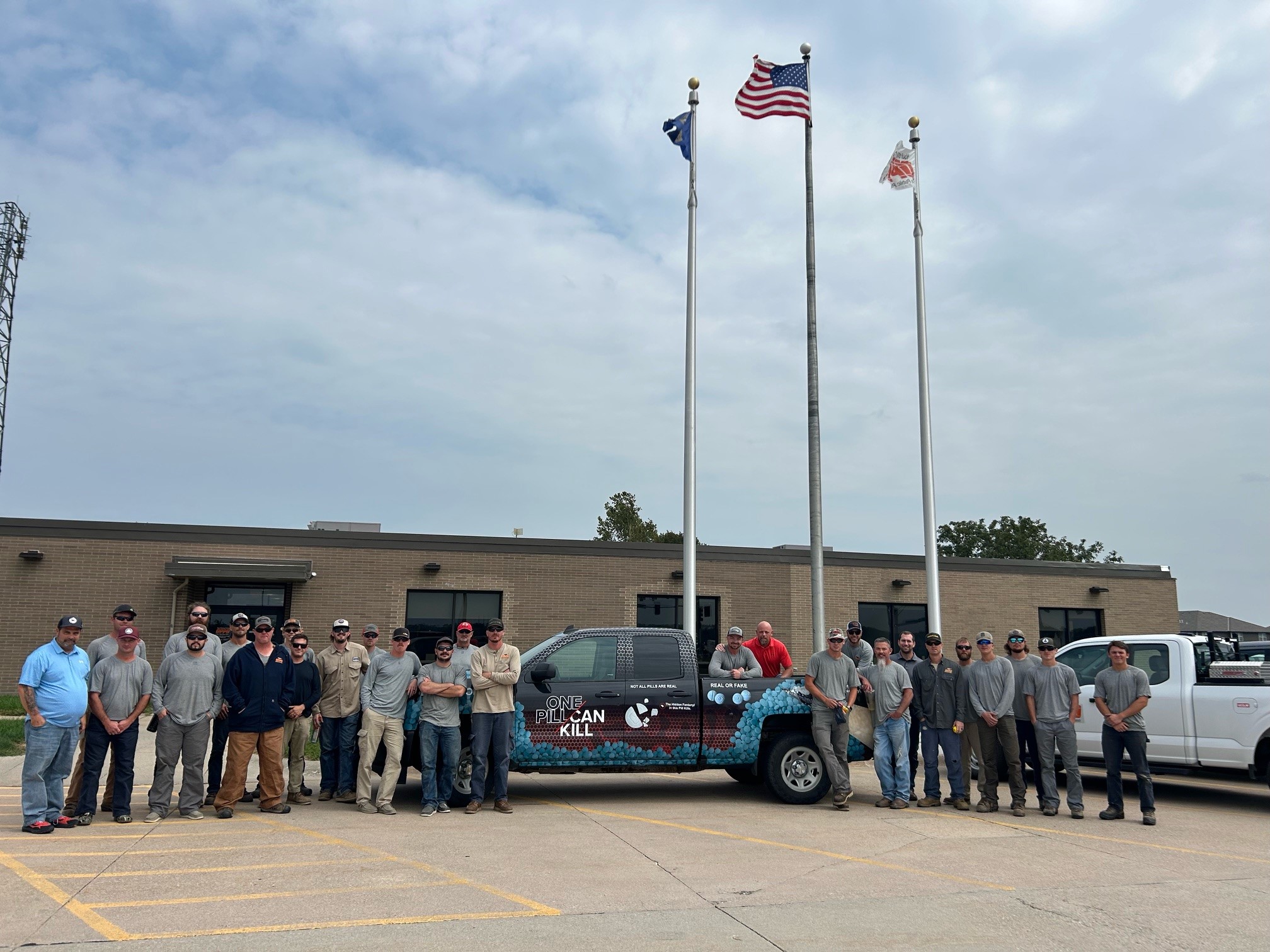 Members of the Omaha Public Power District stand around the DEA Omaha Division One Pill Can Kill truck.