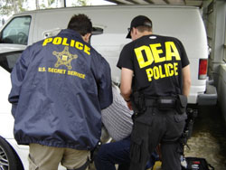 U.S. Secret Service and DEA special agents search for concealed traps and hidden compartments in seized vehicle.