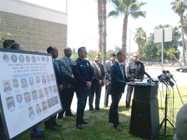 DEA ASAC Chris Evans to the right of the Operation Crystal Light Target Poster, AUSA Shawn Nelson at the podium during a press conference.