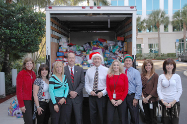 Management of the Drug Enforcement Administration Miami Field Division and Kids in Distress Auxiliary members stand with the truck load of approximately 800 gifts purchased by DEA employees for 300 needy Broward County children.