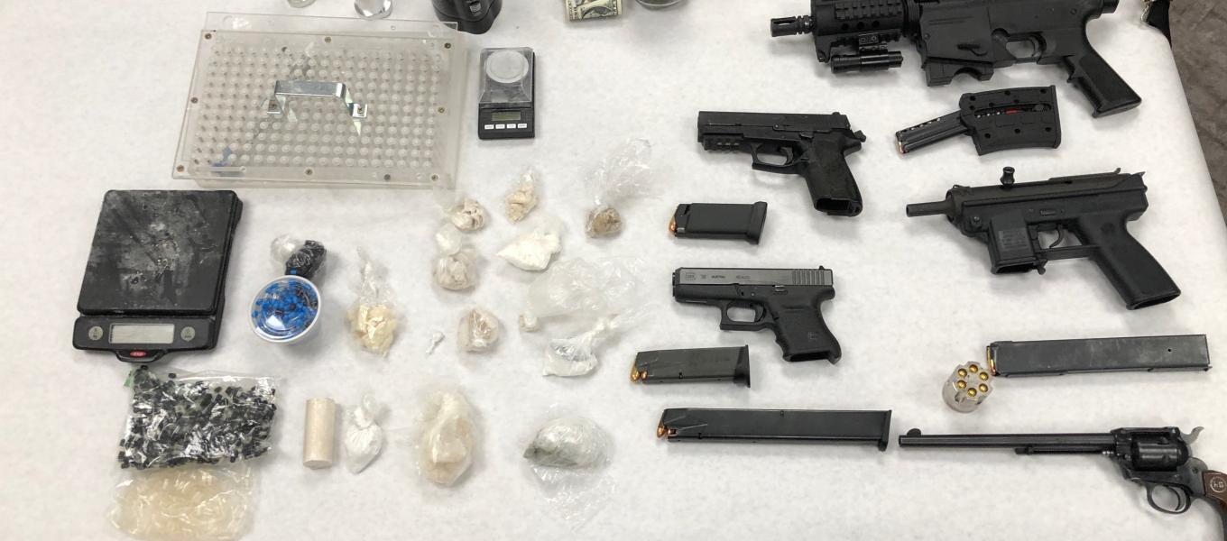 A table displaying drugs and guns.