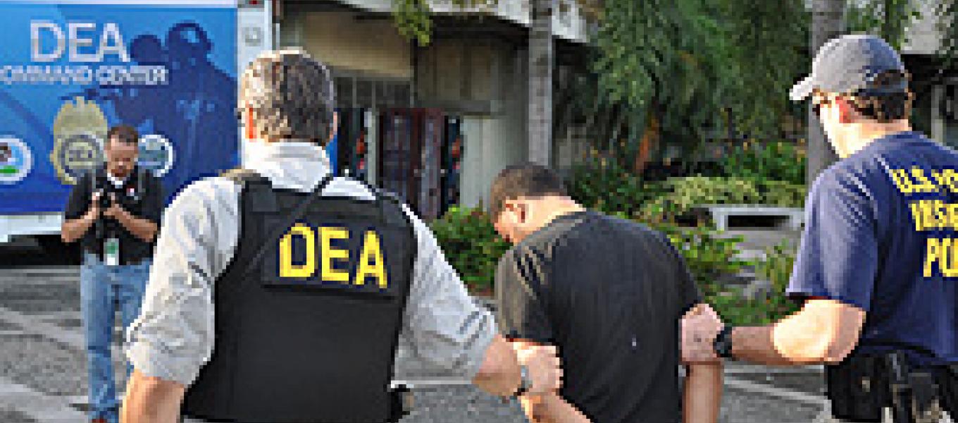 Agents escort a defendant for processing in San Juan, PR