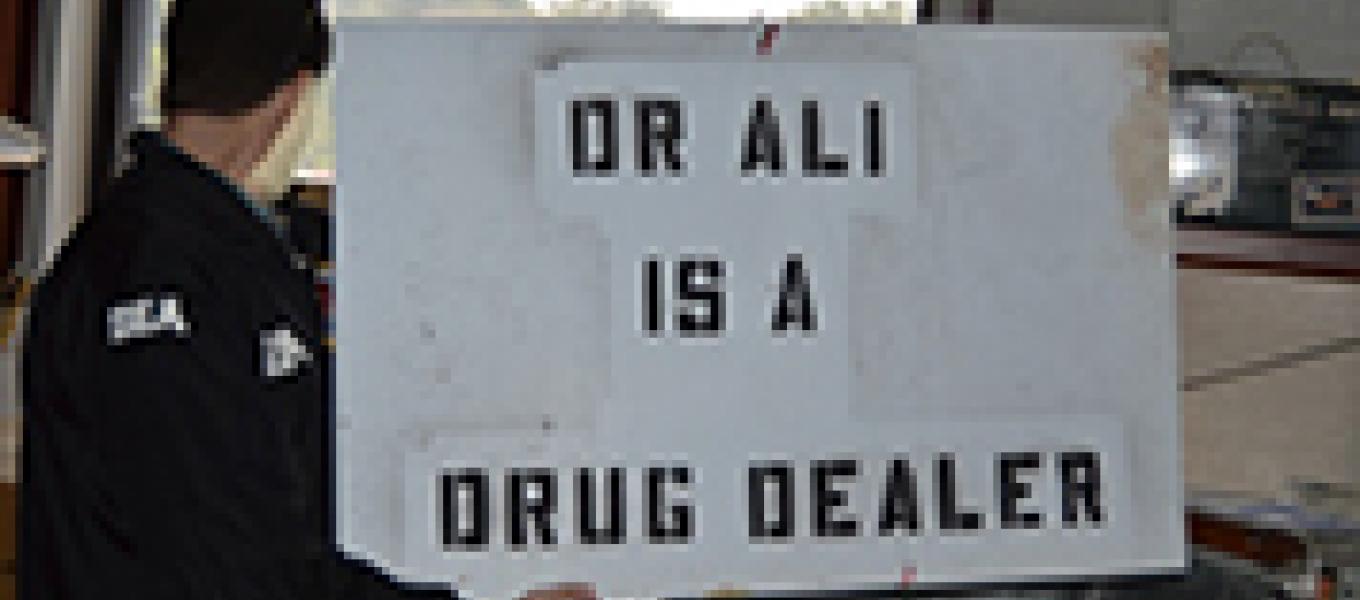 This sign stating “Dr. Ali is a drug dealer”  was found at Dr. Ali’s clinic. DEA learned that the sign was placed in front of the clinic by unknown persons and removed by Dr. Ali.