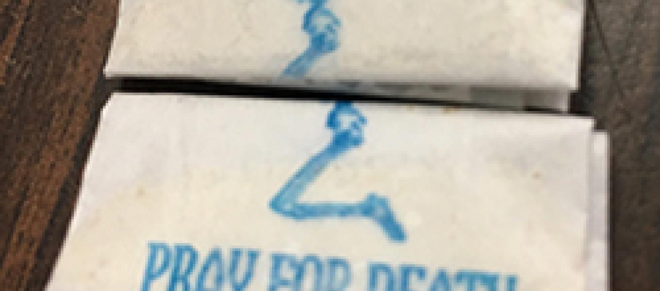 A court authorized search yielded cash and 215 glassine envelopes of suspected heroin/fentanyl stamped with an image of a kneeling skeleton and the brand name “Pray for Death.”